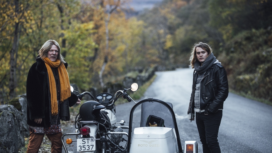 卡斯柏與喬吉站在山中道路上，兩人中間隔著摩托車，面向鏡頭